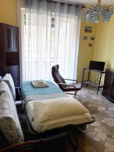 a room with a bed and a chair and a window at Appartamento 500mt stadio San Siro in Milan