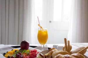 a table with a plate of food and a glass of orange juice at Central Hotel Panama Casco Viejo in Panama City