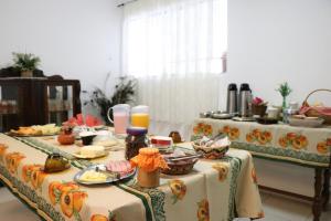 a table with two tables with food on it at Pousada Alvorada Brotas - e agendamento das atividades turísticas in Brotas