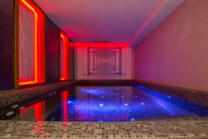 uma piscina num quarto com luzes vermelhas em Lamaraz Hotels em Argel