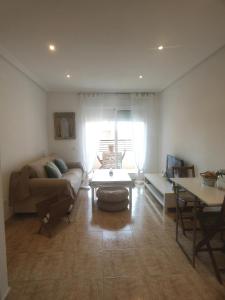 a living room with a couch and a table at Apartamento Juan Sebastian El Cano in Santa Pola