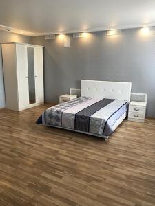a bedroom with a bed and a wooden floor at Gostinyy dvor in Elista