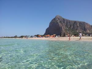 a group of people walking on the beach at HOME HOLIDAY PINO&FABIANA in San Vito lo Capo