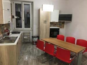 サレルノにあるB&B Cuore di Salernoのキッチン(木製テーブル、赤い椅子付)