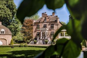 a large brick house with a grass yard at Kasteeltje Hattem in Roermond