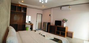 1 dormitorio con 1 cama grande y TV en Mailuay Resort, en Buriram