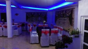 a banquet hall with white tables and red flowers at Camere de închiriat AnneMaryy in Arbore +119 photos