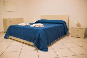 a bedroom with a blue bed with towels on it at Twinsuite in Licata
