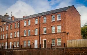 a large red brick building with white windows at The Racecourse Gathering in Chester