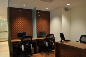 an office with two desks with two monitors and chairs at Adarsh Hamilton in Bangalore