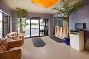 a living room with a couch and a tv at Canadas Best Value Inn-Richmond Hill in Richmond Hill