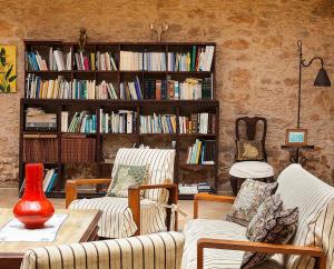 a living room with two chairs and a book shelf with books at Hotel Rural Era de la Corte - Adults only in Antigua