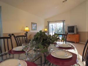 a dining room with a table with plates and wine glasses at 3 Bedroom Standard Davenport Home FL 33897 in Orlando