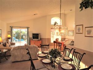 a living room with a table and a dining room at 3 Bedroom Standard Davenport Home FL 33897 in Orlando