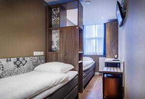 een kleine kamer met 2 bedden en een raam bij The Old Nickel Hotel in Amsterdam