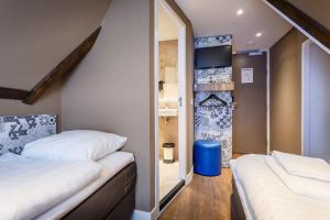 a small room with two beds and a mirror at The Old Nickel Hotel in Amsterdam