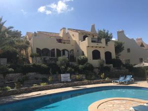 ein Haus mit einem Pool vor einem Haus in der Unterkunft La Manga Club Los Altos 1 in Atamaría