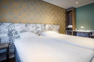 a bedroom with a large white bed in it at The Old Nickel Hotel in Amsterdam