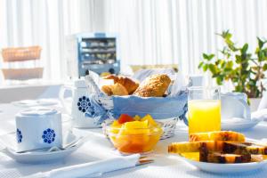 a table with a basket of bread and a glass of orange juice at Hotel Roc E Mare in Propriano