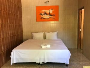 a bedroom with a white bed in a room at Pousada Rancho do João in Pirenópolis