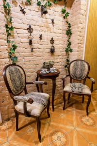 two chairs and a table in a room with a brick wall at Golden Fleece Guest House in Saint Petersburg