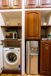a kitchen with a washing machine and a microwave at Golden Fleece Guest House in Saint Petersburg
