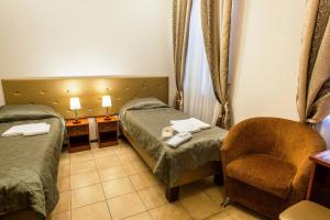 une chambre d'hôtel avec deux lits et une chaise dans l'établissement Golden Fleece Guest House, à Saint-Pétersbourg