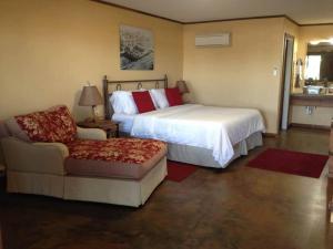 a bedroom with a bed and a couch and a chair at HH Creek Inn in Seymour