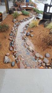 um jardim com pedras e um banco num passeio em HH Creek Inn em Seymour