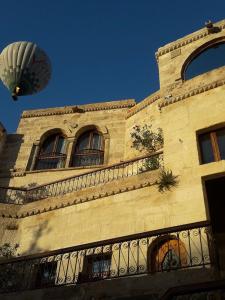 a hot air balloon flying over a building at Erenbey Cave Hotel in Göreme