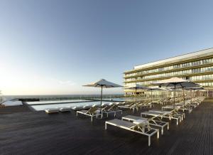 a row of chairs and umbrellas on a boardwalk at Parador de Cádiz in Cádiz