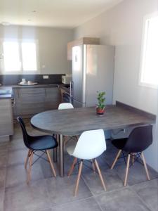 eine Küche mit einem Tisch mit Stühlen und einem Kühlschrank in der Unterkunft La Petite Maison in Ouches