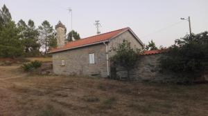 an old stone building with a tower in a field at Casa de Malhoes in Vilares