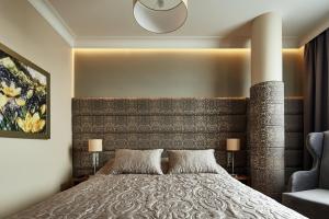 a bedroom with a large bed with a large headboard at Aparthotel Best Views in Krakow