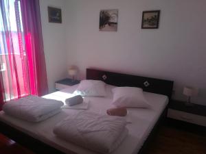 a bedroom with a bed with two pillows on it at Odvojak Apartments in Crikvenica