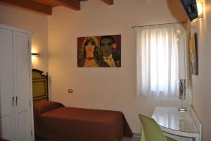 Schlafzimmer mit einem Bett, einem Tisch und einem Fenster in der Unterkunft Bed & Breakfast Palazzo Ducale in Andria