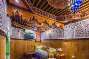 a room with wooden walls and a couch and a table at Riad Hiba in Meknès