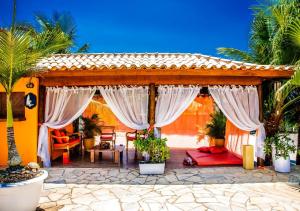 a house with a patio with white drapes at Villa Baobá in Búzios