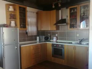 a kitchen with wooden cabinets and a white refrigerator at Odvojak Apartments in Crikvenica