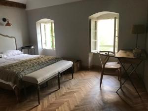 1 Schlafzimmer mit einem Bett, einem Schreibtisch und 2 Fenstern in der Unterkunft The Little House in Gornji Orahovac
