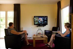 a group of people sitting in chairs in a living room at Erve Woolderink in Wierden