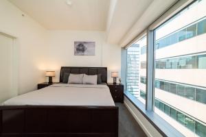 um quarto com uma cama e uma grande janela em Luxurious Highrise 2b 2b Apartment Heart Of Downtown LA em Los Angeles