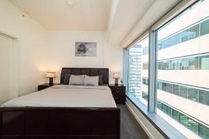 1 dormitorio con cama y ventana grande en Luxurious Highrise 2b 2b Apartment Heart Of Downtown LA en Los Ángeles