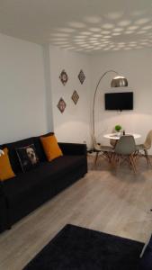 uma sala de estar com um sofá preto e uma mesa em ML Apartments Almada panoramic balcony no Porto