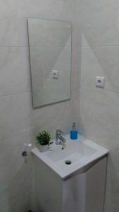 uma casa de banho branca com um lavatório e um espelho em ML Apartments Almada panoramic balcony no Porto