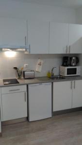 uma cozinha com armários brancos e um micro-ondas em ML Apartments Almada panoramic balcony no Porto