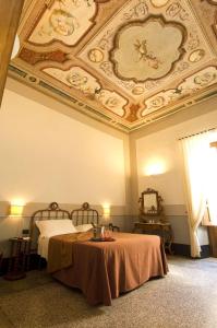 una camera con due letti e un soffitto elegante di Hotel Palazzo D'Erchia a Conversano