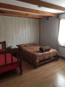 エル・カラファテにあるホステル デ ラス マノスのベッドルーム1室(ベッド1台、テーブル、窓付)