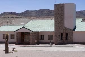 a building with a green roof in the desert at Hotel de Las Nubes in San Antonio de los Cobres