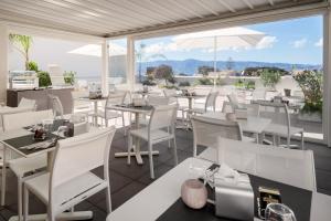 ein Restaurant mit weißen Tischen und Stühlen und einem großen Fenster in der Unterkunft Hotel Medinblu in Reggio di Calabria